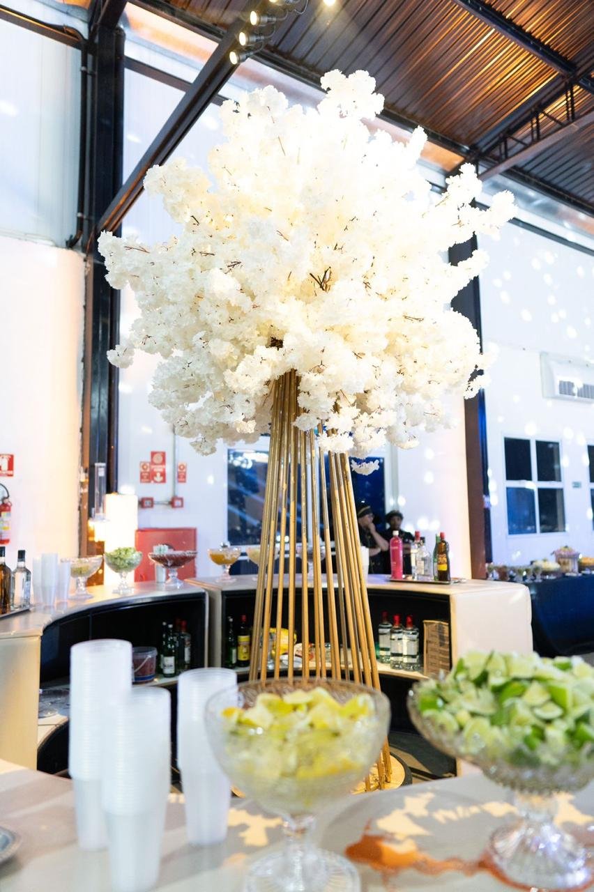 Arranjo alto de flores brancas sobre o bar da festa de formatura
